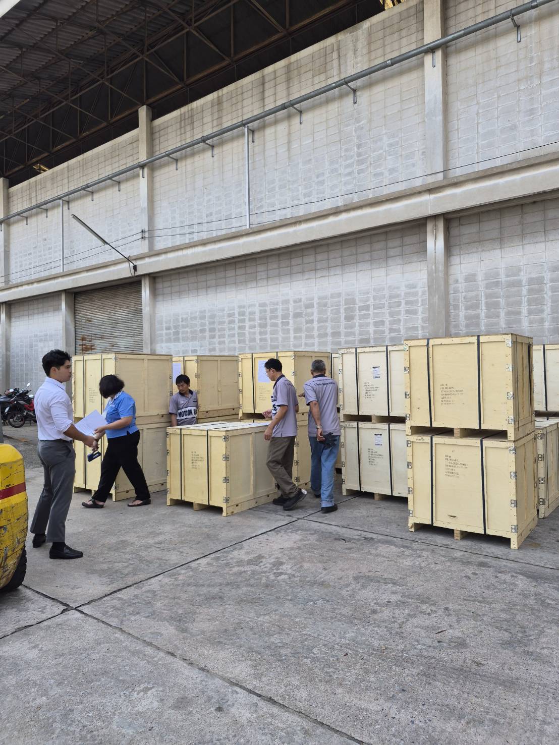 MPC team conducting delivery inspection of wooden export crates outside warehouse